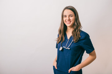 cheerful young female doctor with stethoscope over neck looking at camera isolated on white