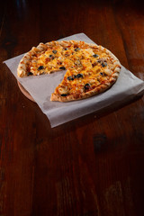 Pizza on a wooden dark background in a bar