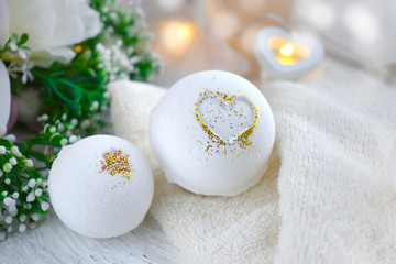 Obraz na płótnie Canvas Close up bath balls with heart, towel, flowers on light background. Romantic spa lifestyle concept for Valentines day, Mothers day or wedding greeting card.