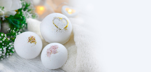 Obraz na płótnie Canvas Close up bath bombs with roses, towel on light background. Romantic spa lifestyle concept for Valentines day, Mothers day or wedding banner. Copyspace.