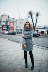 Fototapeta premium Girl in a gray coat in the winter in the city