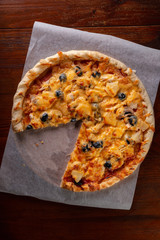 Pizza on a wooden dark background in a bar