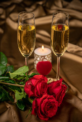 Valentine's day card, two glasses of champagne on a gold background red roses and a red heart, a lighted candle