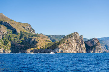 Fototapeta na wymiar Amalfi coast shores view from the water with some boats cruising. Positano, Italy.