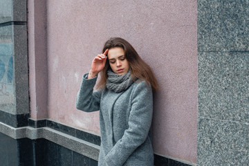 Girl in a gray coat in the winter in the city