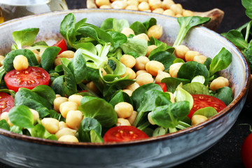 chickpea salad with ingredient and tomatoes and lamb´s lettuce. healthy salad