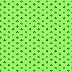 St. Patrick's day. Small clover shamrocks on a green background. Pattern for design.