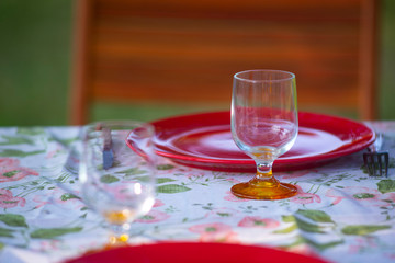 France. Art de la table. couverts sur une table. Assiette et verre sur une nappe en tissu fleurie.  Table art. cutlery on a table. Plate and glass on a flowered cloth tablecloth