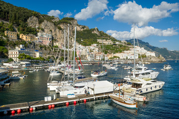 Fototapeta na wymiar Sailing yachts and catamarans at Amalfi port. Sailing cruise route spot in Italy.