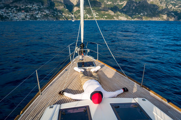 Man relaxing at teak deck of luxury sailing yacht. Amalfi coast, Italy.