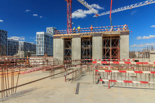 concrete pump building under construction. Concrete pump on high rise building under construction site with crane. Cement mixer truck with pump is preparing to put concrete on foundation. 