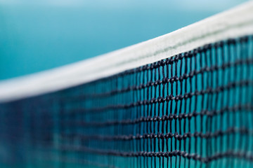 Tennis net and blue court. Individual sport