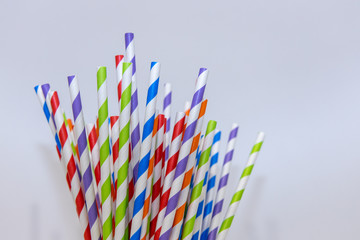 Bright striped paper straws in a white background