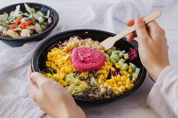 Buddha bowl healthy food concept. Vegan detox salad with quinoa and beet hummus on a white background. Instagram style with hands eating