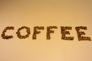Coffee grains on a light backround.   inscription of coffee.