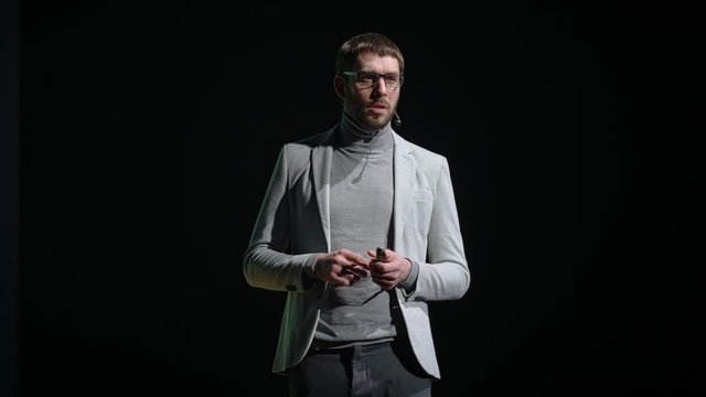 Business Conference Stage: Caucasian Visionary Startup CEO Presents New Product, Does Motivational Talk Science, Technology, Entrepreneurship, Development, Leadership. Black Background 