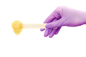 Pasta for sugar depilation shugaring on spatula, white background