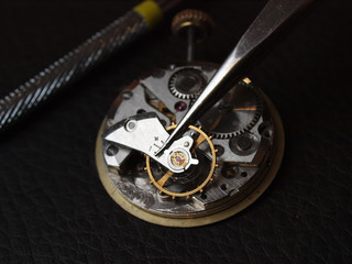 watchmaker repairing old watch mechanism