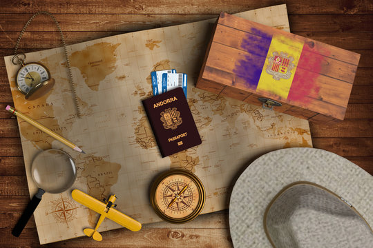 Top view of traveling gadgets, vintage map, magnify glass, hat and airplane model on the wood table background. On center, official passport of Andorra and your flag.