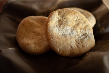 Pan de campo sobre tela oscura con rastros de harina