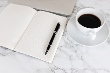 Open Notebook with Blank Page and coffee and laptop in the background