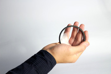 Hand holds clear or uv protector lens camera filter on white background