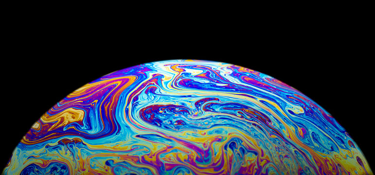 Macro picture of soap bubble psychedelic color on black background
