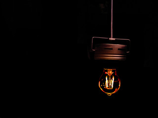 1920s style Vintage retro light bulb on minimalist black background