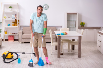 Young injured man cleaning the house