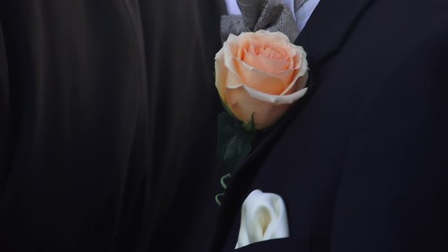 A groom in a tuxedo and boutineer - close up detail shot on formal attire.