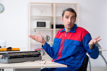 Young repairman repairing air-conditioner at warranty center