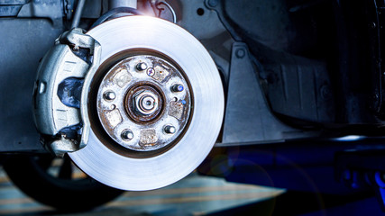 Closeup car disk brake maintenance service in car garage and copy spcae - obrazy, fototapety, plakaty