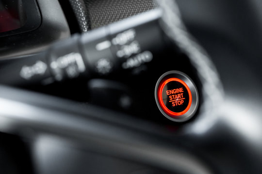 Close up modern car engine start stop button on black leather car console and copy space