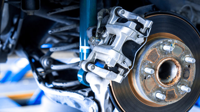 Closeup car disk brake maintenance service in car garage and copy spcae