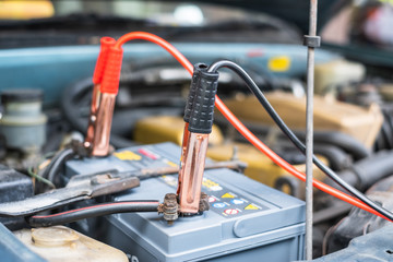 Charging a car battery with electricity through cables from another car