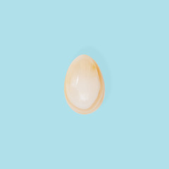 Decorative Easter egg made from Natural gemstone onyx. Trendy spring holiday greeting card. Minimal flat lay background.
