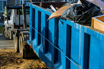 Loading the garbage container old and used construction material in the new building construction...