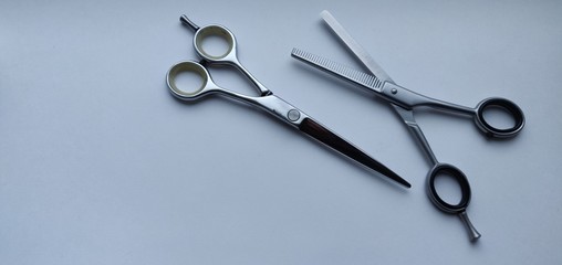 open thinning scissors, and hairdressing scissors, lie next to a white cold background
