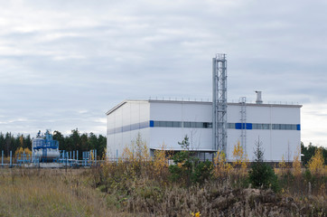 Industrial building located in a forest zone, against the blue sky.