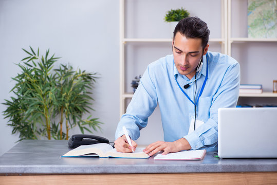 Young Male Travel Agent Working In The Office