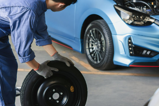 Asian man car inspection Measure quantity Inflated Rubber tires car.Closeup hand holding tire and blue car for tyre pressure measurement for automotive, automobile Car industry image