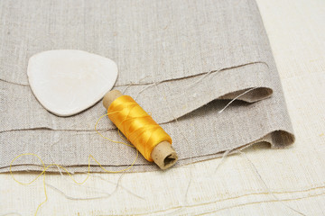 Linen fabrics of different textures and multi-colored threads on the reels. Sewing theme