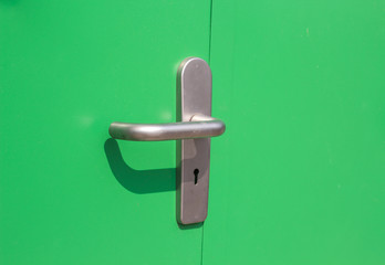 Aluminum door knob on the green door skin.