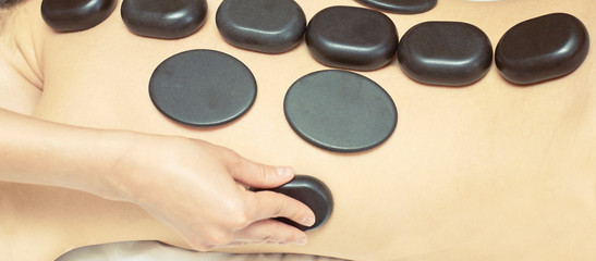 Obraz na płótnie Canvas body stone massage. Hot rock masseur. Girl at salon with doctor hands. Relax spa resort
