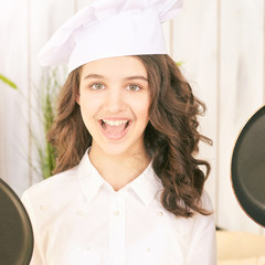 Young girl at kitchen. Little cook chef. Cute female portrait. Baker smile professional