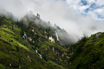 view of the annapurna circuit himalaya nepalstream ofwater and waterfal with dramatic haze sky - obrazy, fototapety, plakaty