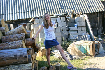 A girl in the village stacks firewood