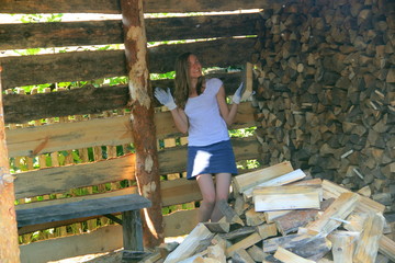 A girl in the village stacks firewood