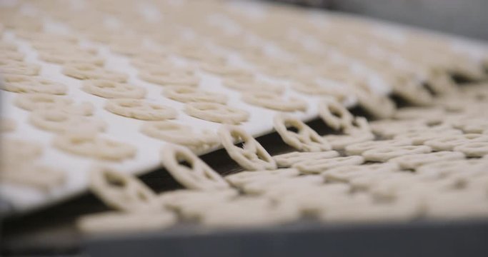 Snacks production Closeup conveyor, raw pretzel ready for baking