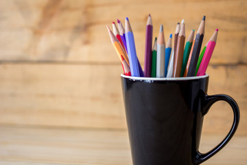 color pencils in pen holder on wooden table